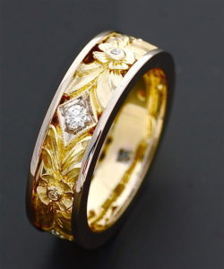 A gold ring with some flowers and leaves on it