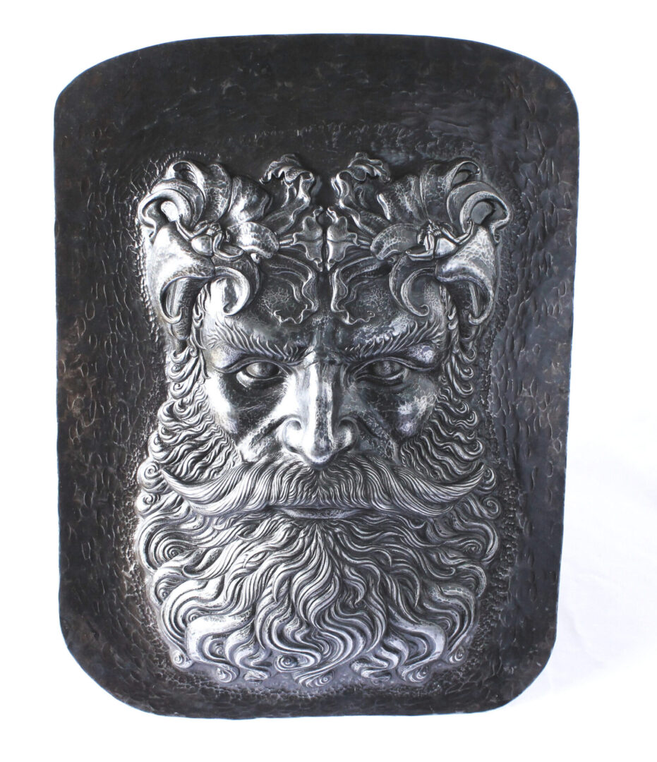head of a person with a beard engraved on metal