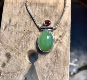 a necklace with a large green gem