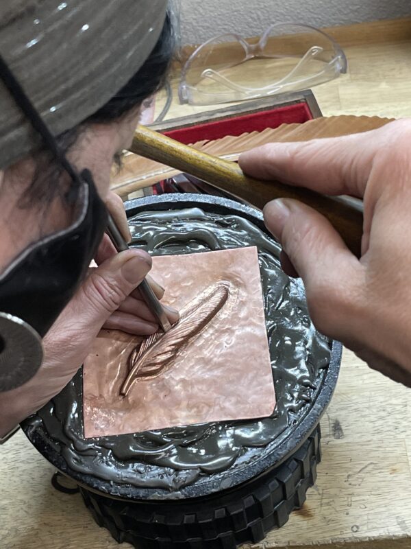 A person is carving some type of object into it.